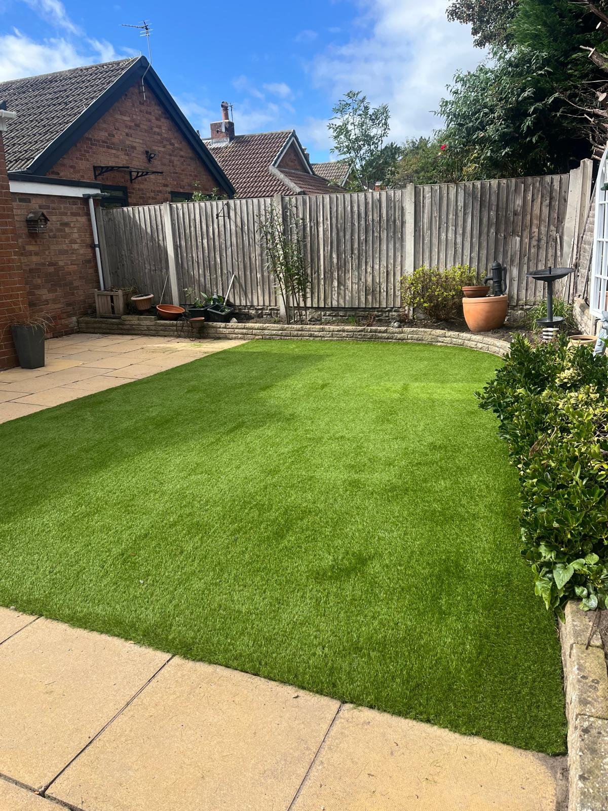 A back garden artificial lawn with a patio